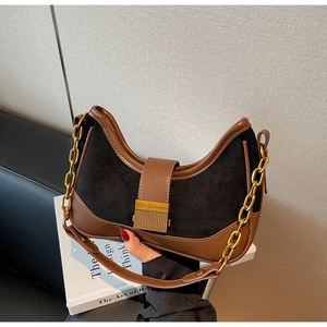 Detail of a vintage contrast color half-moon underarm bag with gold metal chain and suede