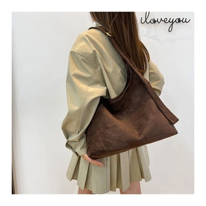 Modella che indossa una borsa hobo grande in finto camoscio marrone scuro con tracolla