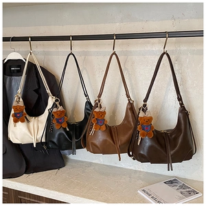Row of pleated leather hobo bags in four colors with cute teddy bear bag charms