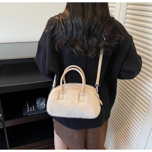 Close-up of off-white fluffy faux fur crossbody bag with leather handles and silver hardware