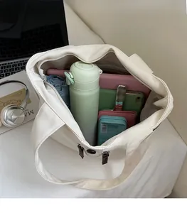 Top view showing the spacious interior of an off-white canvas tote with essential items