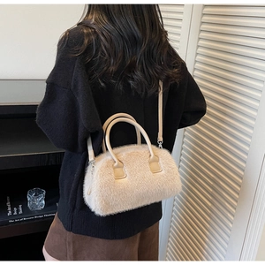 Close-up of fluffy beige faux fur crossbody bag with leather handles and silver hardware