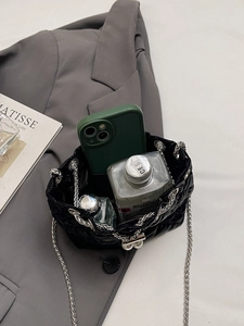 Detail view of quilted mini bucket bag with silver chain strap and pearl decor