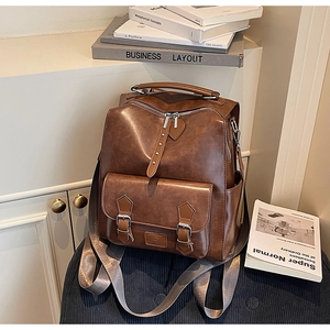 Retro brown leather backpack with multiple pockets shown in a cozy library setting
