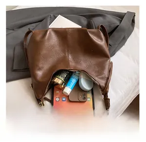 Interior view of brown pleated crossbody bag showing large capacity for tablet and phone