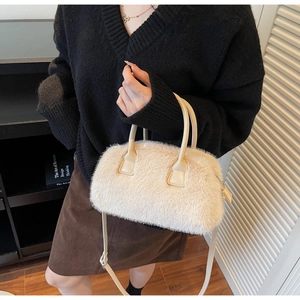 Detailed view of off-white faux fur handbag with leather handle and adjustable strap