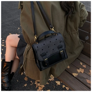Detailed view of vintage polka dot crossbody bag on outdoor bench with autumn leaves