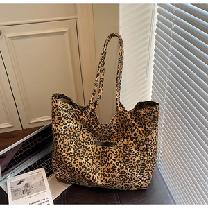 Macro detail of leopard print canvas tote bag featuring premium fabric texture and shoulder strap