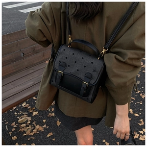 Outdoor shot showing back view of vintage polka dot backpack with dual leather straps