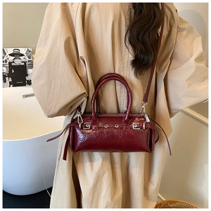 Detail of wine red oil wax leather baguette bag featuring vintage silver buckle hardware