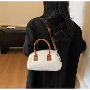 Detail showing plush white faux fur texture on a stylish Boston bag with brown leather straps