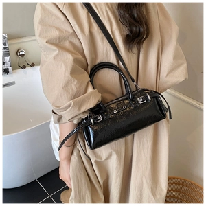 Detail view of the black patent leather texture and silver buckles on the Boston shoulder bag