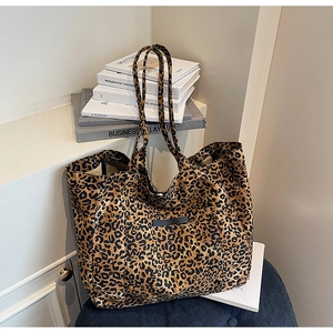 Detail of leopard print tote bag featuring black label pocket on durable fabric texture