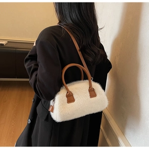 Close-up of fluffy white faux fur texture and brown leather strap on the Boston bag