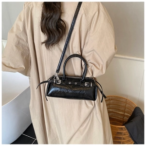 Detail of vintage black wrinkled patent leather bag with silver metal buckle and hardware