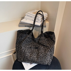 Detail of leopard print tote bag with front pocket and durable canvas fabric texture