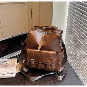 Macro shot of retro brown leather backpack details showing buckle flap and texture