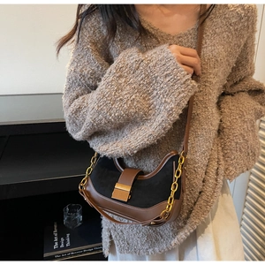 Detalle de bolso retro bajo el brazo con cadena dorada y hebilla metálica en escena real