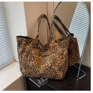 Close-up of leopard print tote bag with logo patch against a mirror in a cozy setting