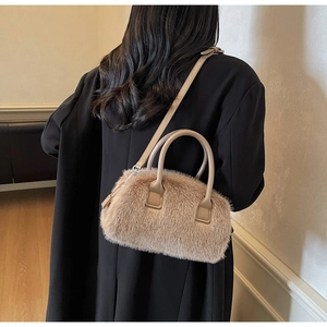 Detail of plush fuzzy handbag in light brown with leather handle and detachable strap
