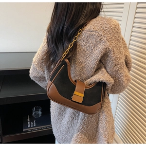 Détail d'un sac sous le bras demi-lune avec chaîne dorée et boucle métallique texturée