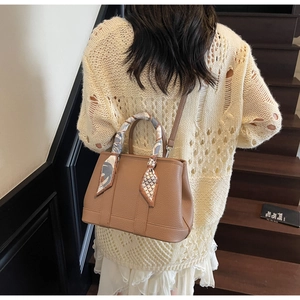 Brown lychee leather handbag detail with decorative silk scarf and detachable strap