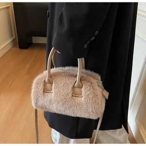 Close-up of fluffy faux fur handbag with premium leather handles and metal zipper detail