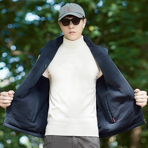 Men's navy reversible fleece vest with stand collar and zipper pockets in outdoor setting