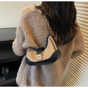 Détail d'un sac demi-lune bicolore rétro avec bandoulière chaîne dorée sur mannequin