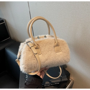 Detail of beige faux fur handbag showing soft texture, leather handles, and shoulder strap