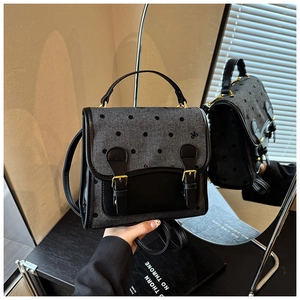 Mirror reflection showing details of gray polka dot messenger bag with leather trim