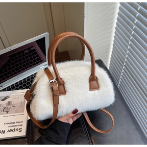 Close-up of white fluffy faux fur handbag with brown leather handles and silver hardware