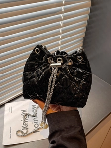 Chic black quilted drawstring bucket bag with silver chains and pearl charms for women