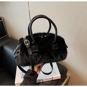Detail of black faux fur handbag featuring leather handles and silver zipper accents