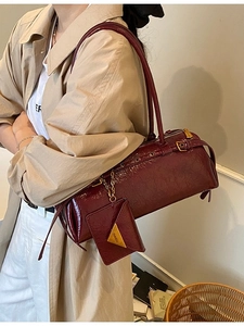 Burgundy faux leather baguette bag with metal rivets and matching mini purse attachment