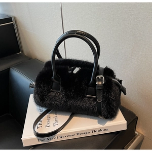 Detail of black faux fur shoulder bag with leather handles and silver hardware