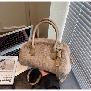 Detail of soft beige faux fur handbag with PU leather handle and silver hardware accent