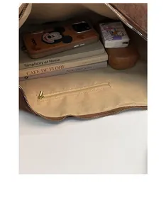 Interior view of large suede crossbody bag showing roomy storage with zipper pocket