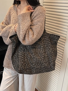 Large leopard print tote bag with front pocket shown worn over a shoulder