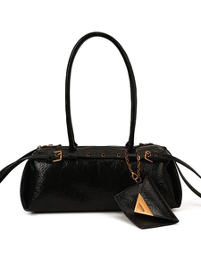 Chic black baguette bag in glossy oil wax leather with gold chain and coin purse detail