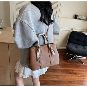 Brown lychee leather bucket bag with decorative heart pattern silk scarf on handle