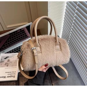 Detail of light brown faux fur bag with leather straps and silver hardware in soft light
