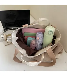 Top view of large canvas tote bag interior with laptop, bottle and umbrella