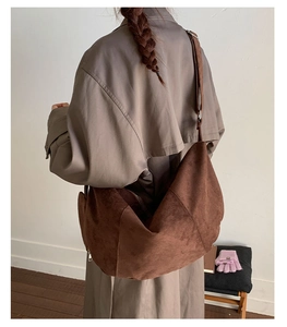 Brown suede hobo bag on model showing large capacity and soft texture for daily use