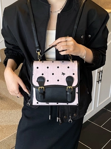 Pink and black polka dot backpack with bow detail and vintage buckle straps
