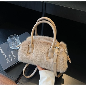 Detail of plush faux fur handbag featuring leather handles and adjustable crossbody strap