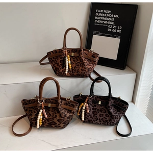 Detailansicht von Eimertaschen mit Leopardenmuster, Holzperlen-Quasten und Lederriemen