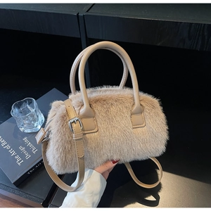 Close-up of beige faux fur boston bag with twin handles and adjustable leather strap