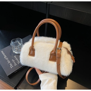 Detail of white faux fur Boston bag featuring brown leather handles and silver hardware
