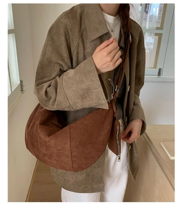 Detail of caramel suede crescent shoulder bag with knotted strap and small pouch